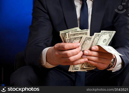 Businessman counts money in hands.