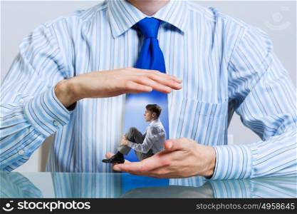 Businessman covered with palms. Miniature of businessman in palm protected with care