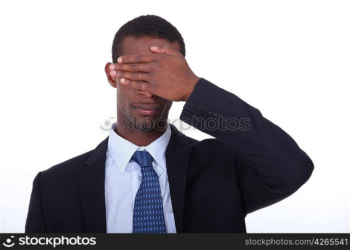 Businessman covering eyes with hand