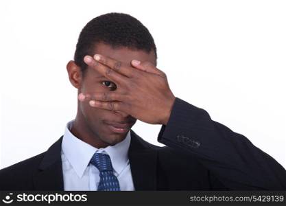 Businessman covering face with hand