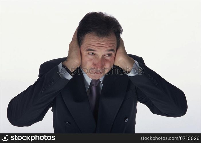 Businessman covering his ears with his hands