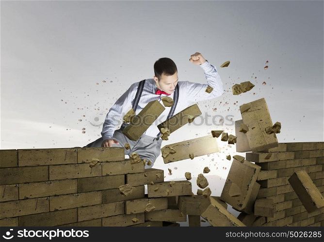 Businessman crashing bricks. Determined businessman breaking stone bricks with hand punch
