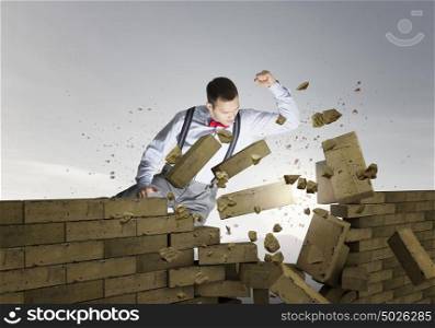 Businessman crashing bricks. Determined businessman breaking stone bricks with hand punch