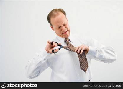 Businessman cutting necktie