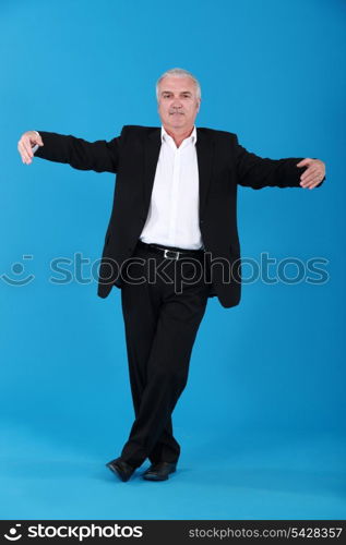 Businessman dancing alone on blue background