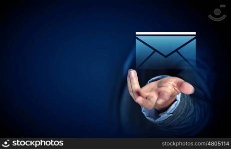 Businessman demonstrating email concept. Close up of businessman palm holding email icon on dark background