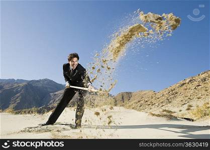 Businessman Digging With Spade in the Desert