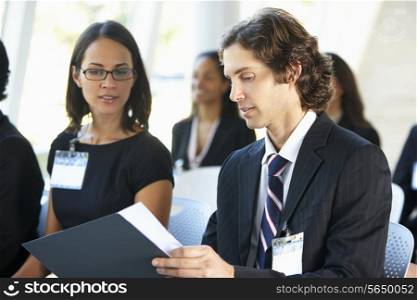 Businessman Discussing Conference Document With Colleague