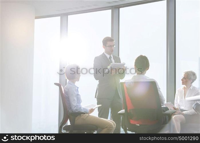 Businessman discussing with colleagues in boardroom at office