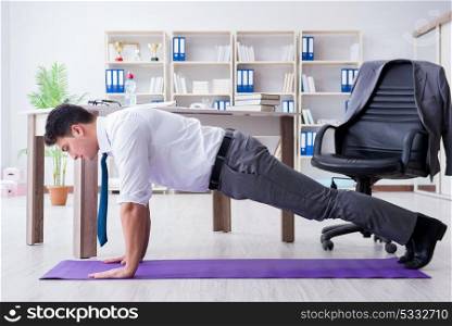 Businessman doing sports at his office space