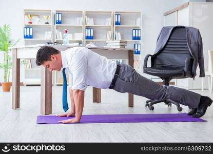 Businessman doing sports at his office space