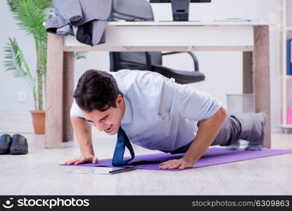 Businessman doing sports in office during break