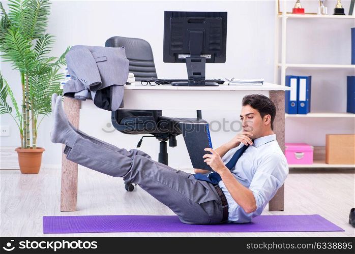 Businessman doing sports in office during break