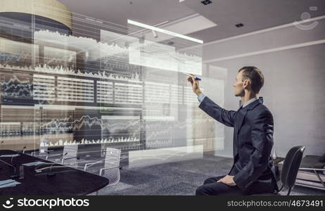 Businessman draw progress concept mixed media. Young businessman sitting in chair and drawing with marker on media screen