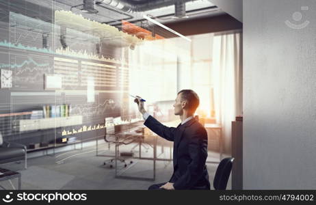 Businessman draw progress concept mixed media. Young businessman sitting in chair and drawing with marker on media screen