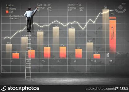 businessman drawing diagram. businessman standing on ladder drawing diagrams and graphs