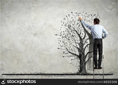 Businessman drawing graphics. Back view image of businessman drawing graphics on wall