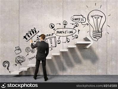 Businessman drawing his ideas. Businessman spraying his business ideas from aerosol can