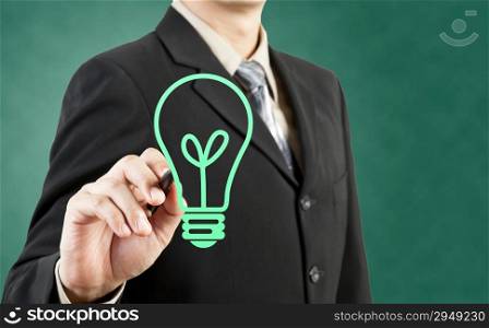 Businessman drawing light bulb green concept