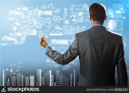 Businessman drawing plan. Rear view of businessman touching digital screen