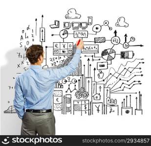 Businessman drawing sketches on wall