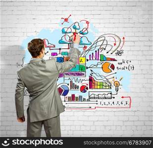 Businessman drawing sketches on wall