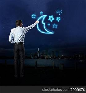 Businessman draws a moon and stars