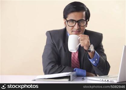 Businessman drinking coffee at desk