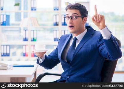 Businessman drinking coffee in the office during break