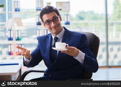 Businessman drinking coffee in the office during break