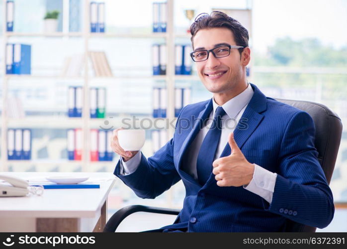 Businessman drinking coffee in the office during break