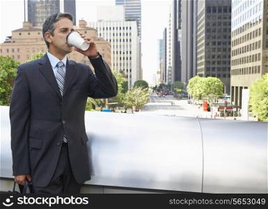 Businessman Drinking Takeaway Coffee Outside Office