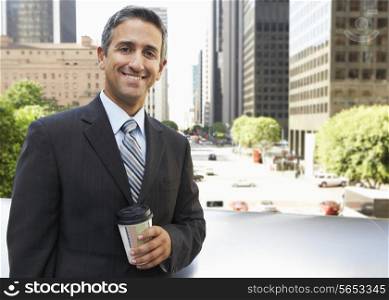 Businessman Drinking Takeaway Coffee Outside Office