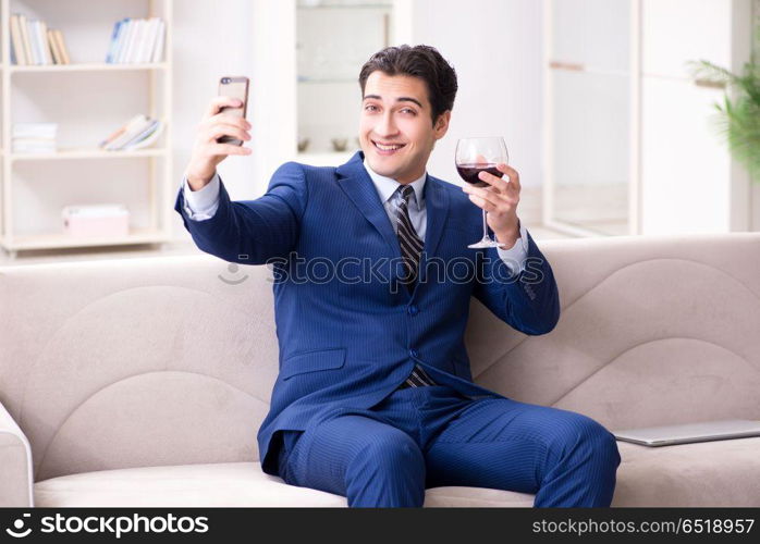 Businessman drinking wine sitting at home