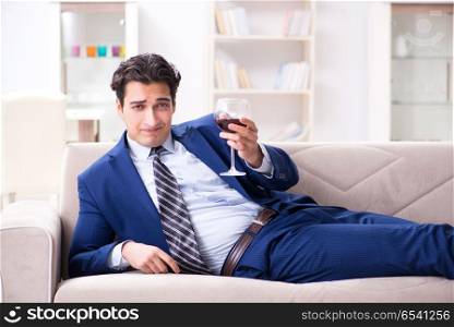 Businessman drinking wine sitting at home