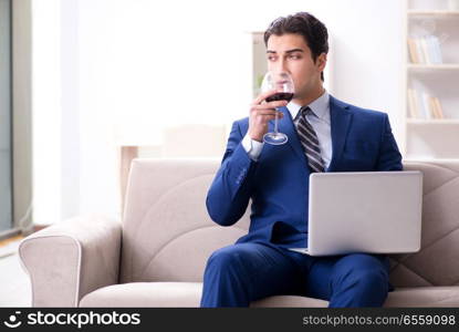 Businessman drinking wine sitting at home