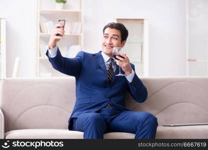 Businessman drinking wine sitting at home