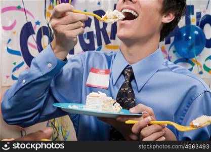 Businessman eating party cake