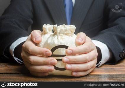 Businessman embraces euro money bags. Financing business project or education. Trade, economics. Corruption. Provision financial loan credit. Bank deposit. Budget, tax collection. Subsidies, savings.