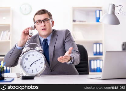 Businessman employee in urgency and deadline concept with alarm . Businessman employee in urgency and deadline concept with alarm clock. Businessman employee in urgency and deadline concept with alarm