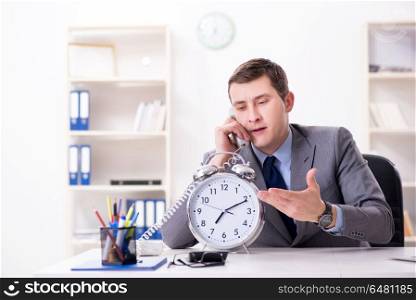 Businessman employee in urgency and deadline concept with alarm . Businessman employee in urgency and deadline concept with alarm clock. Businessman employee in urgency and deadline concept with alarm