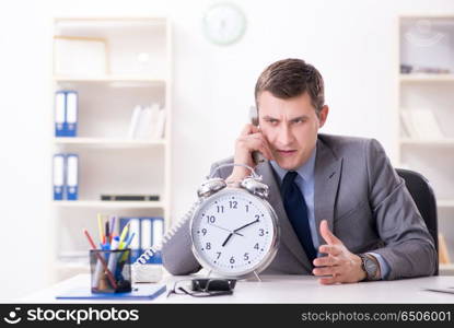 Businessman employee in urgency and deadline concept with alarm . Businessman employee in urgency and deadline concept with alarm clock. Businessman employee in urgency and deadline concept with alarm