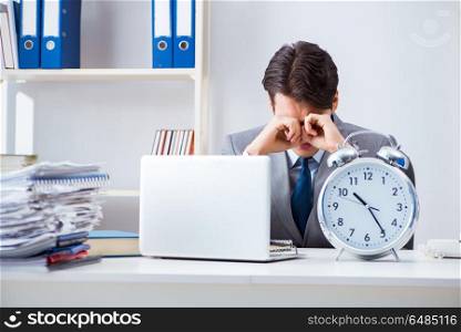 Businessman employee in urgency and deadline concept with alarm clock