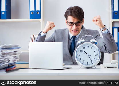 Businessman employee in urgency and deadline concept with alarm clock