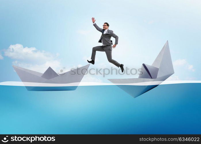 Businessman escaping sunken paper boat ship