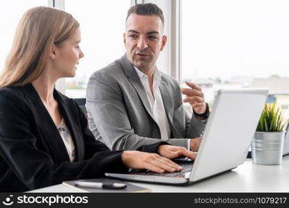 Businessman executive is in meeting discussion with a businesswoman worker in modern workplace office. People corporate business team concept.