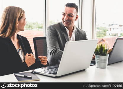 Businessman executive is in meeting discussion with a businesswoman worker in modern workplace office. People corporate business team concept.