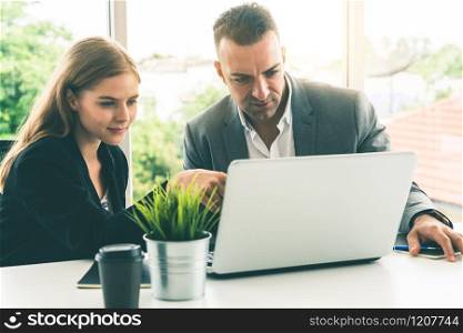 Businessman executive is in meeting discussion with a businesswoman worker in modern workplace office. People corporate business team concept.. Businessman and businesswoman working in office.