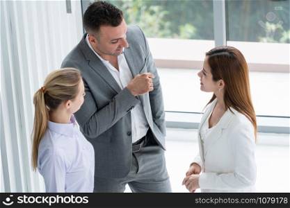 Businessman executive is in meeting discussion with colleague businesswomen in modern workplace office. People corporate business team concept.
