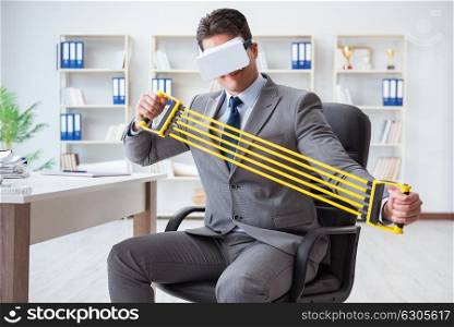 Businessman exercising with elastic expander wearing VR glasses